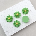 Detail of green resin daisy charms with yellow centers and flat back for DIY crafts - Green