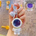 Luminous astronaut keychain with white spacesuit, gold trim and purple starry planet helmet - Glowing Astronaut-Gold