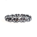 Vue macro du bracelet en perles d'hématite avec maillons fléchés et éclat métallique sombre - W + Perles rondes 4MM