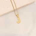 Macro shot of gold letter J pendant with honeycomb texture on box chain and stone base - Letter J