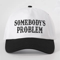 Close-up of SOMEBODY'S PROBLEM embroidery on a black and white two-tone baseball cap - White and Black Splicing