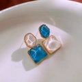 Dettaglio macro di orecchini geometrici in marmo blu e bianco con bordo dorato - Perno in argento-Blu