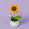 Detail einer handgehäkelten Sonnenblume mit lila Blumen im weißen Keramiktopf - Sonnenblume mit Violetten Puffs