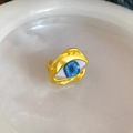 Detalle de anillo dorado de ojo turco vintage con iris azul y textura de lava fina - Dorado