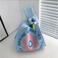 Detail view of light blue knitted tote bag with pink floral patterns and flower pendant - Sunflower - Blue