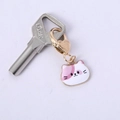 Detail of pink and white cat enamel keychain with gold heart clasp and silver lock key - Pink Cat Head