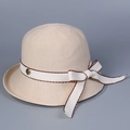 Détail d'un chapeau cloche en tricot beige avec ruban à nœud et bouton fleur dorée - M (56-58cm) / Beige