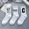 Three white mid-calf cotton socks featuring black graffiti art and bold letter prints - White Numbered Style Set / White