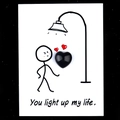 Polished black obsidian heart stone on a decorative card with You light up my life text - Obsidian