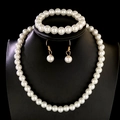 Elegant white pearl jewelry set with necklace, bracelet and earrings on black stand - Gold White