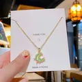 Collier élégant en acier titane doré avec pendentif lune en œil de chat vert et zircons - Lune Verte Colorée