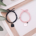Close-up of magnetic heart clasp connecting pink and black woven ghost couple bracelets - Black and Pink (Pair)