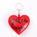 Détail du porte-clés coeur en cuir rouge avec anneau argent et texte 'make it happen' - Cœur Rouge