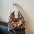 Chic leopard print tote bag with light khaki handles placed on a black book - Leopard Khaki