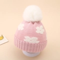 Detailed knit texture of pink baby winter hat featuring a white floral pattern and faux fur pom - 0-12 Months / Pink