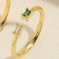 Detailed close-up of a gold open ring with emerald green and white rectangle zircons - Adjustable Open / Emerald and White Zirconia
