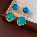 Primer plano de pendientes vintage con gemas redondas azules y cuadradas verdes en caja - Aguja de plata / Estilo Vintage de Bloques de Color Azul Verde / Azul