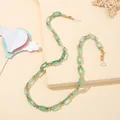 Dettaglio catena per occhiali in acrilico verde chiaro con anelli dorati e moschettoni - Verde