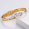 Dettaglio di bracciale a forma di serpente dorato con micro-pavé di cristalli bianchi e neri - Bracciale Serpente / Oro