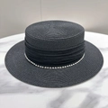 Detalle de sombrero de paja negro con adorno de perlas y textura trenzada elegante - Negro