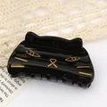 Glossy black cat hair claw clip with gold facial outlines for Halloween hair styling - Cat