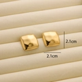 Detail of 18K gold-plated titanium earrings with irregular hammered texture on velvet pad - R183 Wavy Square / Gold