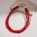 Dettaglio della collana bohémien multistrato con perline di vetro rosse e viola e chiusura dorata - Collana-Rosso-Viola