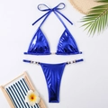 Gros plan d'un bikini bleu métallisé avec perles sur fond de vacances tropicales - Bleu Royal Métallique