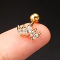 Close-up of a golden crown-shaped tragus piercing with marquise-cut sparkling zircons - Gold Crown Zircon Stud