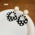 Detailed view of leopard print round earrings with beige beads on a white ceramic tray - Style 9: Black Polka Dot Hollow Out Dangle Earrings with Silver Earring Post
