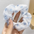Detailed view of white chiffon scrunchie with blue polka dots held in hand - Blue Large Polka Dot