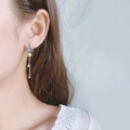 Boucles d'oreilles pendantes avec planète bleue et étoile portées par un mannequin - Style Étoile de Planète Argent