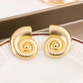 Détail de boucles d'oreilles conque dorées avec une finition texturée polie - Aiguille en argent / Doré