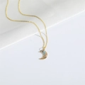 Minimalist gold necklace with a crescent moon pendant inlaid with blue and white stones - Moon (XL3206)