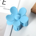 Macro shot of light blue matte flower hair claw clip with frosted texture and spring detail - 7cm / Blue