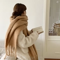 Thick camel mohair scarf with tassels worn by model in a cozy indoor setting - Camel