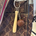 Detailed view of mini wooden baseball bat and leather ball keychain on a vintage brown bag - 7.5CM Long Bat/Coffee Ball