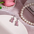 Vue détaillée de boucles d'oreilles ours rose avec cristaux sur fond de soie - Ours Rose