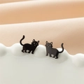Vista macro di orecchini a lobo gatto nero opaco minimalisti su un piatto decorativo - Nero