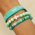 Detail of stacked bohemian bracelets with turquoise fabric, cross charm, and clay beads - Green (DZ-598)