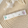 Detail of floral fabric cable organizer on woven mat with heart and round buttons - Pink Ditsy Floral