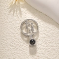 Macro shot of silver dreamcatcher necklace pendant with couple silhouette and projection stone - Couple
