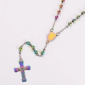 Detailed macro view of iridescent rainbow metal rosary beads with holy medal and cross - Colorful