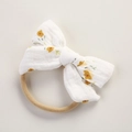 Detail of white muslin baby headband featuring yellow floral bow and beige elastic band - Yellow Floral