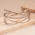 Detail of silver geometric multi-layer open bracelet displayed on beige stone - Silver