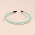 Detail view of a thin headband with turquoise glitter finish and black fabric end tips - Light Green