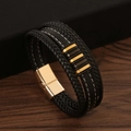 Detailed macro view of multilayered black braided leather bracelet with golden magnetic clasp - Black/Gold