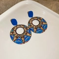 Detail of artistic round earrings with star and moon patterns on a ceramic plate - Bohemian Star Geometric Round Style / Blue