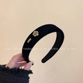 Padded black velvet headband featuring a golden camellia flower and metal logo tag - Gold Camellia Metal Label Style / Black