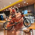 Dettaglio ravvicinato di un mini portachiavi a forma di mountain bike arancione con ruote - Arancione